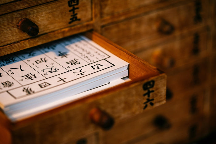 Holzschublade mit Papier und chinesischen Zeichen